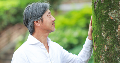 Toshio Matsuba standing in front of a tree